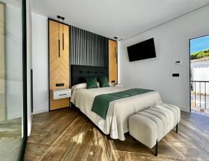 1 dormitorio con 1 cama grande y TV en Hostal Noli, en Chiclana de la Frontera