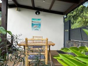a wooden table and chair on a wooden deck at L’Oasis Saint Bernard in Saint-Denis