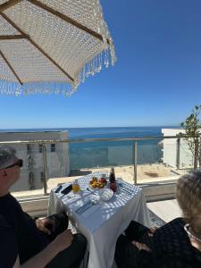 eine Gruppe von Personen, die an einem Tisch mit Aussicht sitzen in der Unterkunft CoastAL in Shëngjin