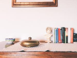 a table with a book shelf with a statue and books at B&B Il Tempo Ritrovato in Canossa
