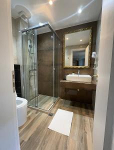 a bathroom with a shower and a sink and a mirror at Hotel Royal Saranda in Sarandë