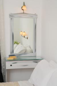 a mirror on top of a table in a bedroom at ARTEMIS beach studios in Kalamaki