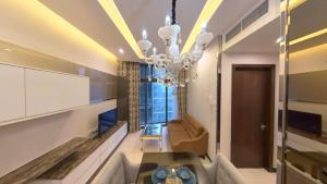 sala de estar con lámpara de araña y sofá en Dorsett Serviced Suites Kuala Lumpur, en Kuala Lumpur
