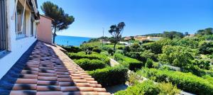 uma vista para um jardim a partir da varanda de uma casa em Le Miroir de la mer em Saint-Aygulf