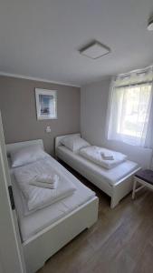 2 camas individuais num quarto com uma janela em Ferienbungalows am Wolziger See em Heidesee