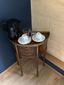 een tafel met twee glazen en een theeservies erop. bij Maison au Coin, proche St Emilion in Sainte-Terre