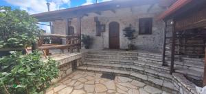 a stone house with stairs and a wooden door at Irini's studios in Zigovístion