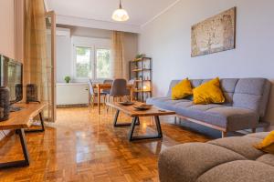 a living room with a couch and a table at Balcony by the bay in Paleo Tsifliki