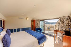 a bedroom with a bed and a balcony at Welcome Hotel in Villefranche-sur-Mer