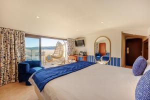 a bedroom with a large bed and a balcony at Welcome Hotel in Villefranche-sur-Mer