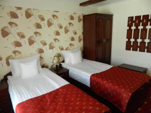 una camera con due letti e una coperta rossa di Schassburger Tor a Sighişoara