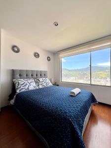 1 dormitorio con cama y ventana grande en Apto completo Atures la mejor vista y ubicación!, en Pasto