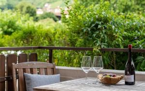 einen Tisch mit zwei Weingläsern und einem Korb mit Trauben in der Unterkunft Ferienwohnung am Kalterer See in Südtirol in Kaltern