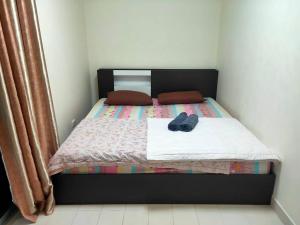a bed with a black headboard and a pair of shoes on it at ป็อปปูล่าคอนโด เมืองทองธานี ใกล้ Impact 酒店 公寓 in Thung Si Kan