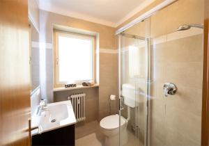 uma casa de banho com um WC, um lavatório e um chuveiro em Ferienwohnung am Kalterer See in Südtirol em Caldaro