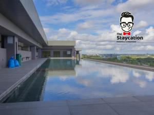 - une vue sur la piscine en face d'un bâtiment dans l'établissement Staycation Homestay 32 The Echelon near Saradise, à Kuching