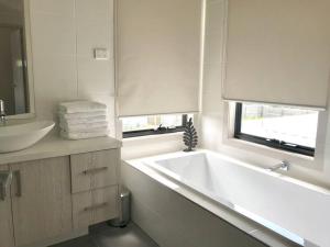 a bathroom with a large white tub and a sink at D110 Sweet Melon super stay-fantastic in Braybrook +17 photos