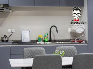 a kitchen with a table and chairs and a counter at Staycation Homestay 32 The Echelon near Saradise in Kuching