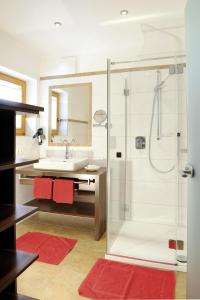 a bathroom with a shower and a sink at Familienhotel Moos-Alm in Lienz +25 photos