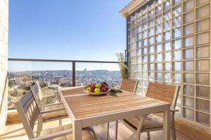 un balcón con mesa y sillas y un bol de fruta en Luxury 4 Bedroom With Amazing View In Ramat Sharet Bayt Vegan en Jerusalén