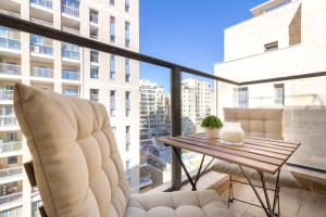 - Balcón con mesa de madera y silla en Luxury 4 Bedroom With Amazing View In Ramat Sharet Bayt Vegan en Jerusalén