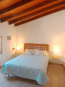 a bedroom with a bed with two lamps on two tables at La Milotxa in Adsubia
