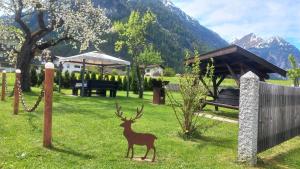 eine Statue eines Hirsches im Gras in der Unterkunft SennHOF Lechtal in Bach