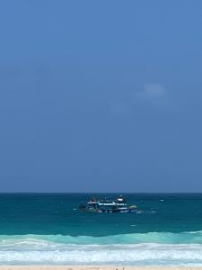 deux bateaux flottant dans l'océan près d'une plage dans l'établissement Villa amoun, à Sidi Krir