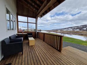 una terraza con 2 sillas, mesa y ventanas en Svansholl Apartments en Kaldrananes