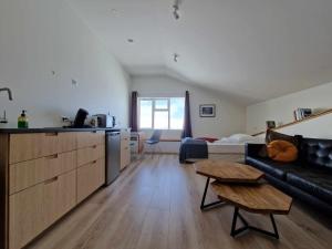 Svansholl Apartments في Kaldrananes: مطبخ وغرفة معيشة مع أريكة وطاولة