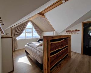 ein Schlafzimmer mit einem großen Bett im Dachgeschoss in der Unterkunft Svansholl Apartments in Kaldrananes