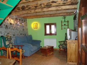 a living room with a blue couch and green walls at Casa Ramón La Caseta in Sin