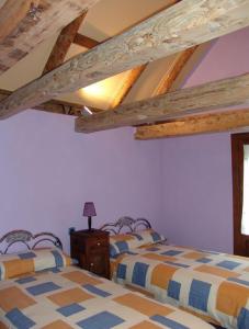 2 camas en una habitación con techos de madera en Casa Ramón La Caseta, en Sin