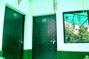 - deux portes vertes dans un bâtiment avec une fenêtre dans l'établissement Radhey Krishna home stay, à Mathura