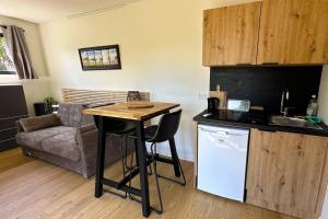 cocina con mesa y sofá en una habitación en AlpiZen centre de Ressourcement, en Coise-Saint-Jean-Pied-Gauthier