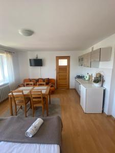 cocina y sala de estar con mesa y sillas. en Nad Doliną Krutyni en Ukta
