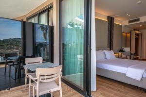 a bedroom with a bed and a table on a balcony at Nobbu Hotel Ksamil in Ksamil