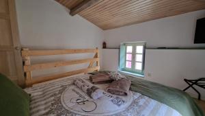 a bedroom with a bed with towels and a window at HOME ET HOLIDAY La Muscadelle in Viviers