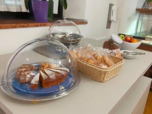 un plato de bollería y una cesta de pan en una barra en Hotel Sirena en Malcesine
