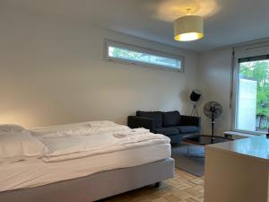 um quarto branco com uma cama e um sofá em Amazing studio in the city centre (Art 12) em Zürich