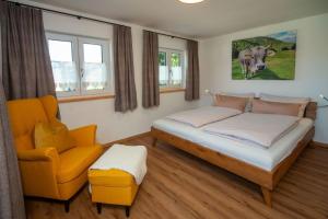 a bedroom with a bed and a chair in it at Ferienwohnung Hüttenschnauzer in Pfronten
