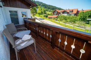 a balcony with a chair and a view of a mountain at Ferienwohnung Hüttenschnauzer in Pfronten +6 photos
