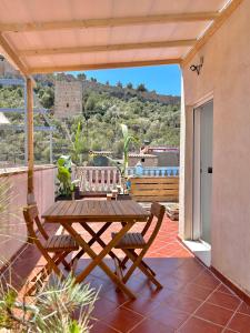 einen Holztisch und zwei Stühle auf einer Terrasse in der Unterkunft Casa con jacuzzi y piscina con vistas al castillo in Corbera de Alcira