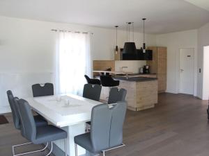 cocina y comedor con mesa blanca y sillas en Burk´s Scheune Comfortable holiday residence 