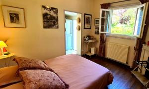 - une chambre avec un grand lit et une fenêtre dans l'établissement Le Jardin Enchanté, à Giverny