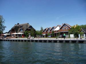 a row of houses on a dock next to the water at Vakantieappartement Eldeufer II in Plau am See