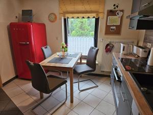 a small kitchen with a table and a red refrigerator at Vakantieappartement Eldeufer II in Plau am See