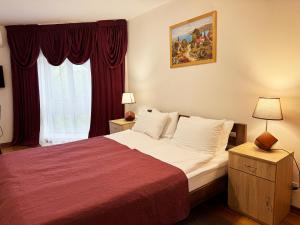 ein Schlafzimmer mit einem großen Bett mit einer roten Decke in der Unterkunft SIGNEEV'S Villa in Kiew