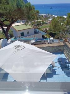 a white umbrella sitting on top of a swimming pool at Casa Le Soleil in Ischia