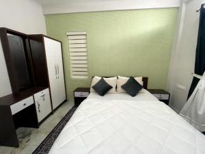 a bedroom with a large white bed with two pillows at Appartment in Ernakulam